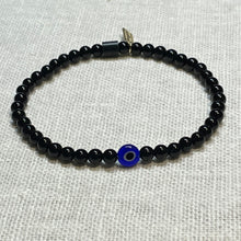 Load image into Gallery viewer, Angled shot of black onyx bead bracelet with glass evil eye bead