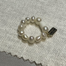 Load image into Gallery viewer, Angled shot of freshwater pearl ring on stretch elastic with Fangirl Unauthorised tag