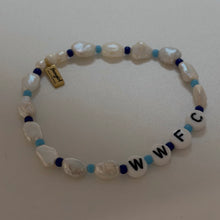 Load image into Gallery viewer, A beaded bracelet with irregular white mother-of-pearl beads, light blue spacer beads, dark blue beads, and white letter beads spelling 'WWFC'. A small gold tag is attached to the bracelet.
