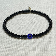 Load image into Gallery viewer, Angled shot of black onyx bead bracelet with glass evil eye bead
