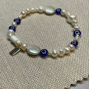 Freshwater pearl and glass evil eye bead stretch bracelet with signature Fangirl Unauthorised tag