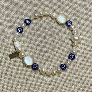 Freshwater pearl and glass evil eye bead stretch bracelet with signature Fangirl Unauthorised tag