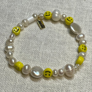 Pearl and smiley face stretch bracelet with signature Fangirl Unauthorised tag