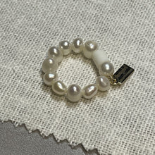 Load image into Gallery viewer, Angled shot of freshwater pearl ring on stretch elastic with Fangirl Unauthorised tag
